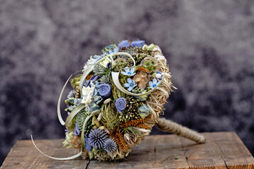 Den blauen Brautstrau fertigte der ungarische Floristmeister Krisztin Kvr. Er kombinierte zu blauen Blten und natrlichem Heu die Wollkordel Dochtfaden in gebrochenem Wei in 5 mm Strke und die dnnere Wollschnur Smartfaden in Porzellanwei.