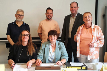 Feierliche Unterzeichnung der umfangreichen Kooperationsvereinbarung in Baunatal. Im Bild sitzend Kathrin Appel-Gllner (links) und Petra Spring. Stehend von links nach rechts Michael Rhein, Stefan Peuser, Christoph Rnnecke und Ulrike Linn.