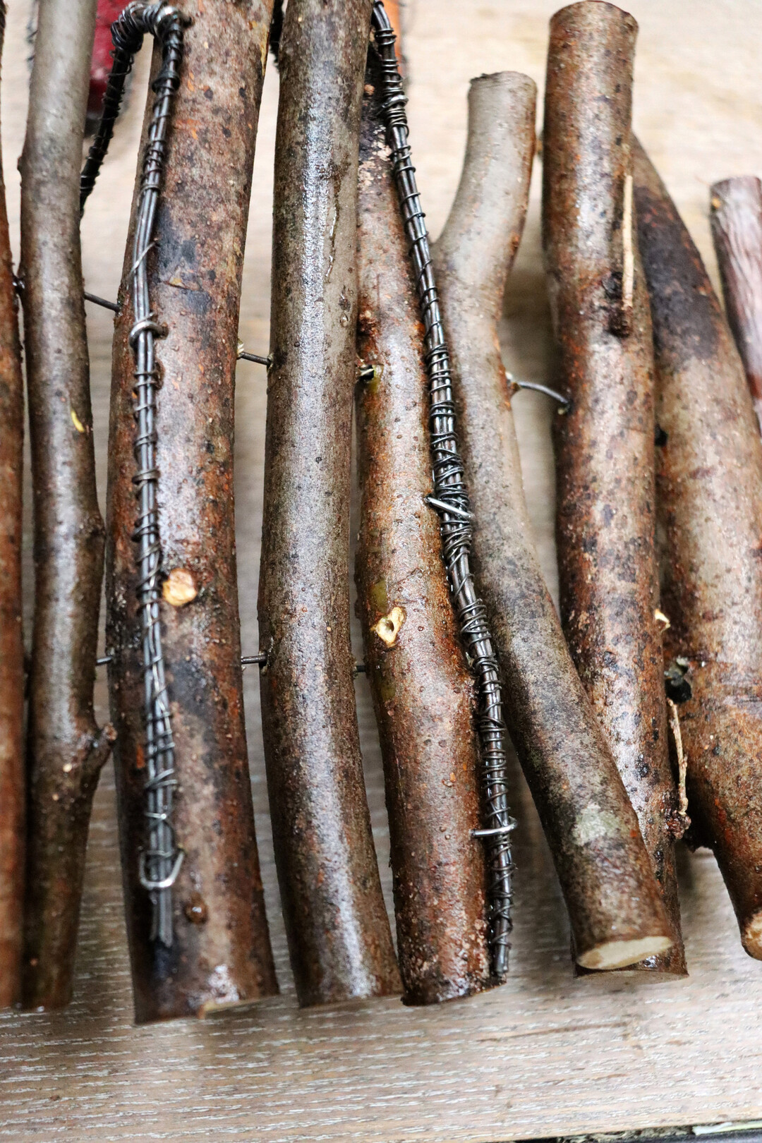 Eine andere Art, die Kerzenhalter zu befestigen, ist, die Drhte mit Krampen in den sten zu verankern. Wichtig ist, dass die Stiele der Kerzenhalter lang sind, um das Gewicht der Kerzen auszubalancieren. Die Hllen selbst werden nicht in der Mattentechnik verwoben, dafr sind die Astvarianten zu schwer. Sie werden auf Spanndraht aufgefdelt. Dafr mssen Lcher gebohrt werden, ja, die Hllen sind eine aufwendige Technik.