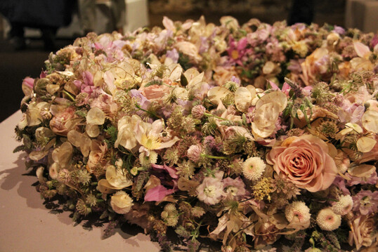 Zarter, in aufgehellten Farben gesteckter Kranz von 
<b>Kevin Wieland.</b>