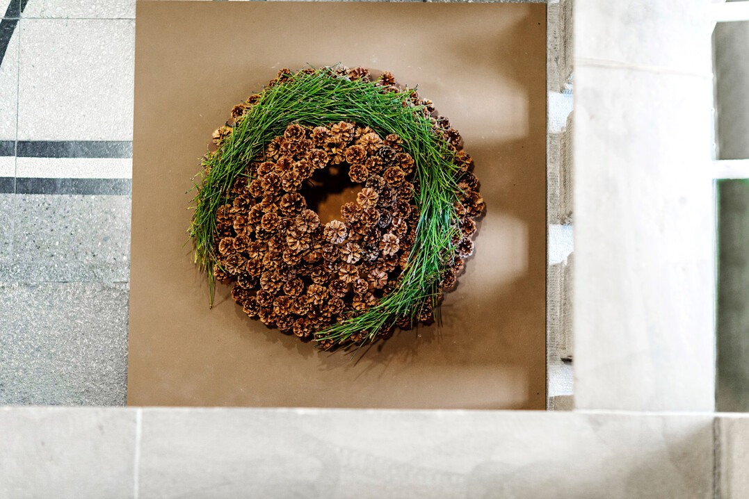Extreme Proportion: Der Kranz aus Kieferzapfen wurde auf Drhte gesteckt. Die Holzplatte, die als Unterlage und technische Grundlage fr die Zapfen dient, wurde gestrichen und mit Hunderten kleinen 1,6 mm groen Lchern versehen. Ebenfalls angebohrt wurden die Zapfen. Als Verbindungsstck zwischen Platte und Zapfen wurden 16er-Drhte verwendet. 