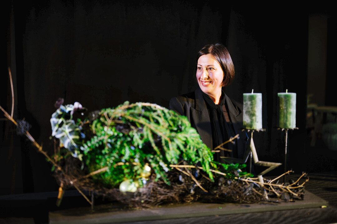 Eine Absolventin mit ihrem Adventsgesteck