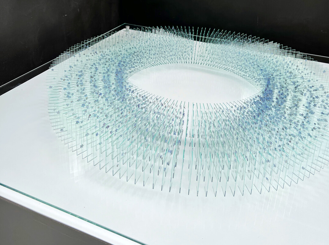 F�r ihre Kranzform brachte Katharina Arnold rund 5.000 einzelne Vergissmeinnichtbl�ten auf 1.000 gl�serne Objekttr�ger auf.