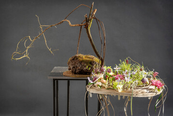 Hier kann man schon von einem �Objekt�, einer Installation sprechen, die Kreation von 
<b>Mehmet Yilmaz</b>
 ist auf jeden Fall mehr als ein �bliches floristisches Werkst�ck. Die �leichten� Bl�ten stehen in einem spannenden Kontrast zu dem ausschwingenden Ast und dem Stein auf dem Tisch, der f�r die Stabilit�t sorgt.