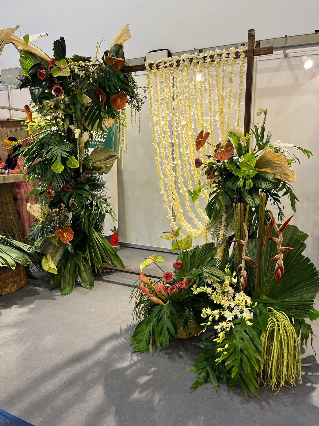 Ein Backdrop f�r eine Hochzeit mit einem Vorhang aus aufgef�delten Dendrobien-Bl�ten. Der Einsatz gro�fl�chiger Bl�tter ist typisch f�r die Floristik auf Hawaii. 