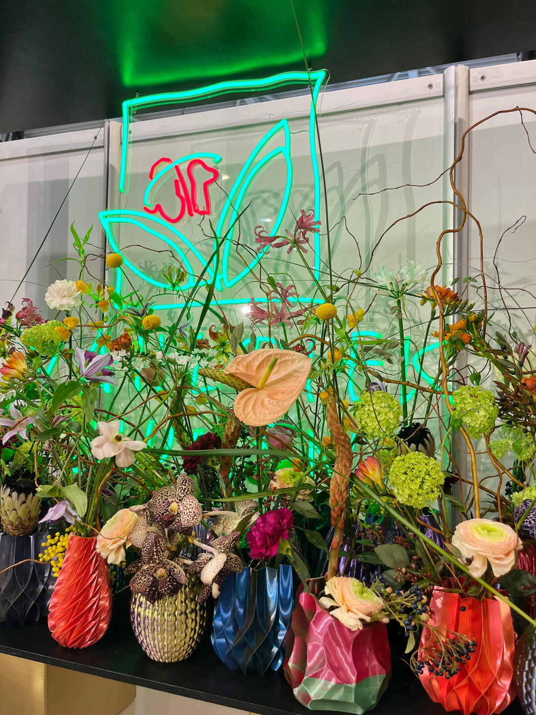 Floral gefüllte Vasen aus dem 3D-Drucker vor dem Logo des Sponsors, Vahldiek.