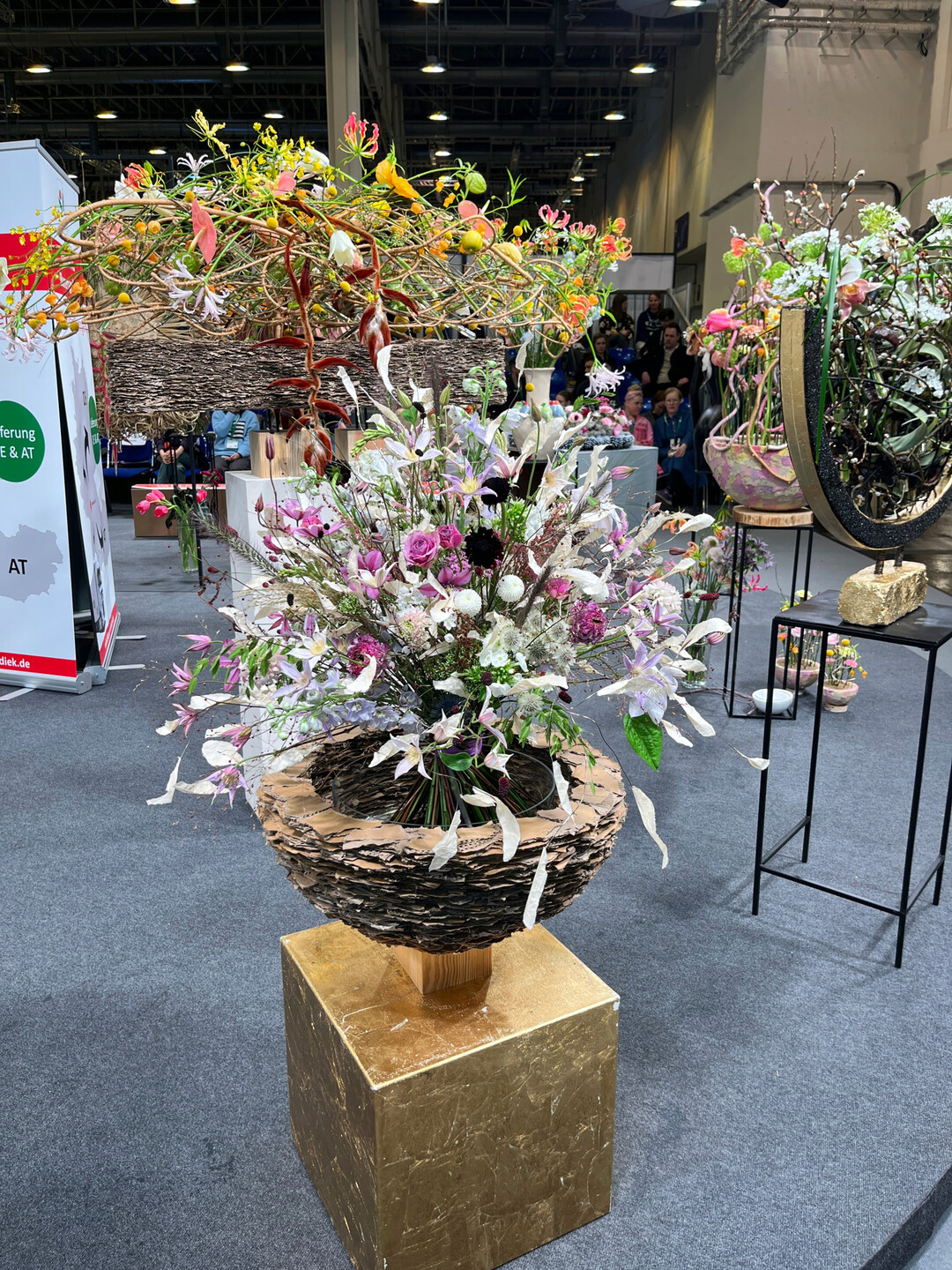 Der goldene Sockel und die selbstgemachte Schale verleihen dem filigranen Strauß einen würdigen Auftritt.