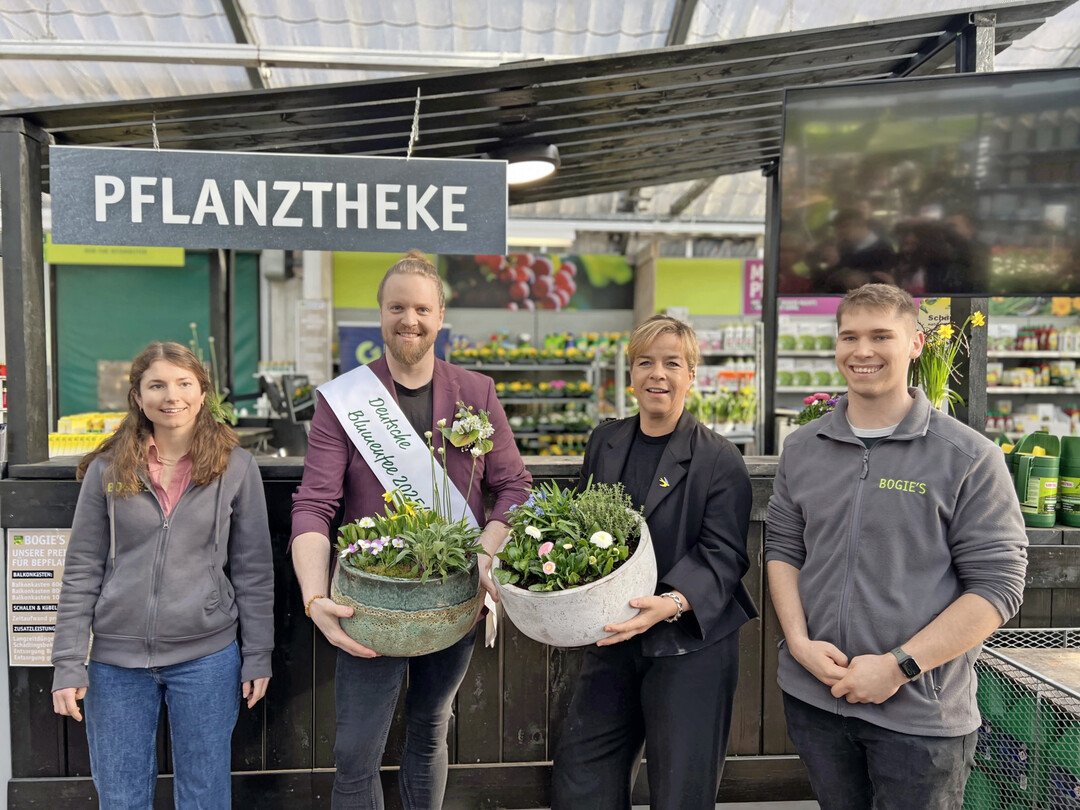 Gemeinsam mit Sophia (links) und Jonas Bogie (recht) präsentiert die Ministerin die von ihr bepflanzte Frühlingsschale. Mit dabei außerdem Hannes Schrader als Deutsche Blumenfee.