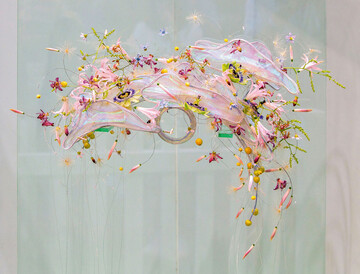 Die Elemente sind holografisch, was dem Werkstck zu besonderem Glanz verhilft. Die Blten sind einzeln auf Draht gefdelt und schweben um die Elemente. Der Schmuck ist auf beiden Seiten abflieend und wirkt wie ein Brautschmuck der Zukunft oder aus einer anderen Dimension. Die Leichtigkeit, die Elizabeth Newcombe hier prsentiert, macht neugierig auf mehr Floristik dieser Art.