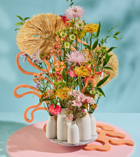 Beach Club nennt das FDF-Trendteam dieses Straudesign im Sommer-Trend Soft Shore. Folgende Floralien wurden verwendet: 
<i>Kniphofia</i>
, 
<i>Lisianthus</i>
, Carnation, 
<i>Echeveria</i>
, Jatropha, Spray Carnation, 
<i>Lathyrus</i>
, 
<i>Celosia, Nerine, Cosmea, Phlox.</i>