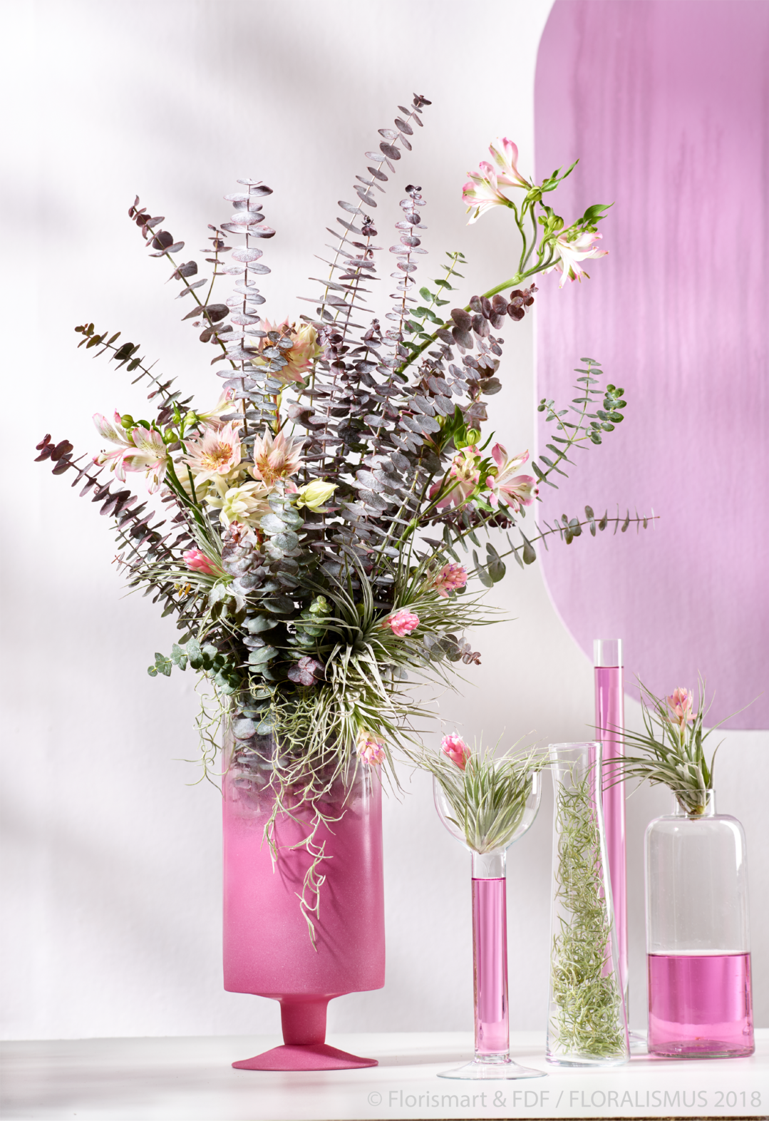 "Delicate Desire", Baby Blue - Einstellstrau mit Eukalyptus: Die pinken Farbverlufe auf dem Gef setzen sich auf dem Strau und in der Wand-Dekoration fort. Die Bltter des Eukalyptus "Baby Blue" spielen die Hauptrolle und sorgen fr einen Girlie-Look.