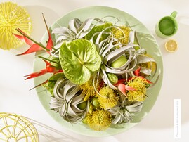 "California Cool": Die frische Kombination aus Blumen und Pflanzen wirkt wie ein spritziges Fruchteis im Hochsommer: Grne Anthurien, gelbe Miniprotea und grau-mintige Sukkulenten-Bltter und die expressiven Helikonie.