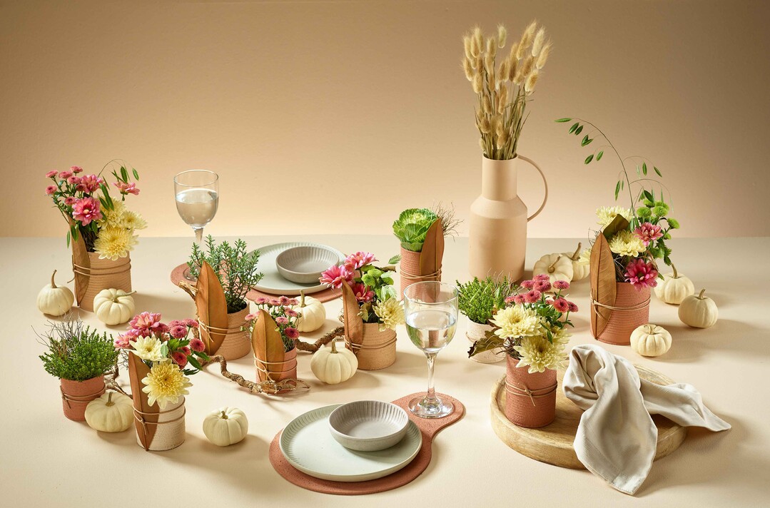 Autumn Atelier: Diese Tisch-Dekoration vermittelt mit Farbharmonie und Natrlichkeit Ruhe und gute Gefhle. Und zum Abschluss kann jeder Gast eine blumige Konserve als mit nach Hause nehmen. Fr die Dekoration werden Konservendosen mit einem Sand-Farbe-Gemisch farbig gestaltet und aufgewertet. Nach dem Trocknen werden sie mit einem Deko-Bndchen und einem Magnolienblatt verziert.
