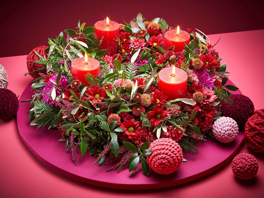 Charming Carmine: Ein festlicher Kranz fr den Advent  aufgekront, ein bisschen wild, gewickelt und gesteckt, ohne Bling-Bling und knstliche Accessoires. Seine Besonderheit ist die Farbgestaltung in Rot- und Grn-Tnen. Gehkelte Kugeln setzen weihnachtliche Akzente.