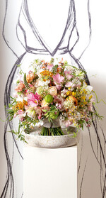 Anna Günther fertigte ihren Strauß ohne Grundgerüst und ohne technische Hilfe frei aus der Hand. Ihr gelang eine perfekte Grundform, die sich weg von der klassischen Kugel in eine ovalere Form auflöst.