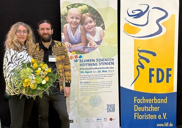 Christopher Ernst, Deutscher Meister der Floristen 2022, und Nicola Fink vom Fachverband Deutscher Floristen, Bundesverband, freuen sich auf die Fortsetzung der Spendenkampagne.