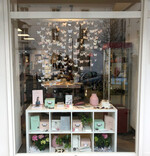 Über dem Tisch flattern Papierschmetterlinge und bringen ein luftiges Frühlingsgefühl in den Laden.