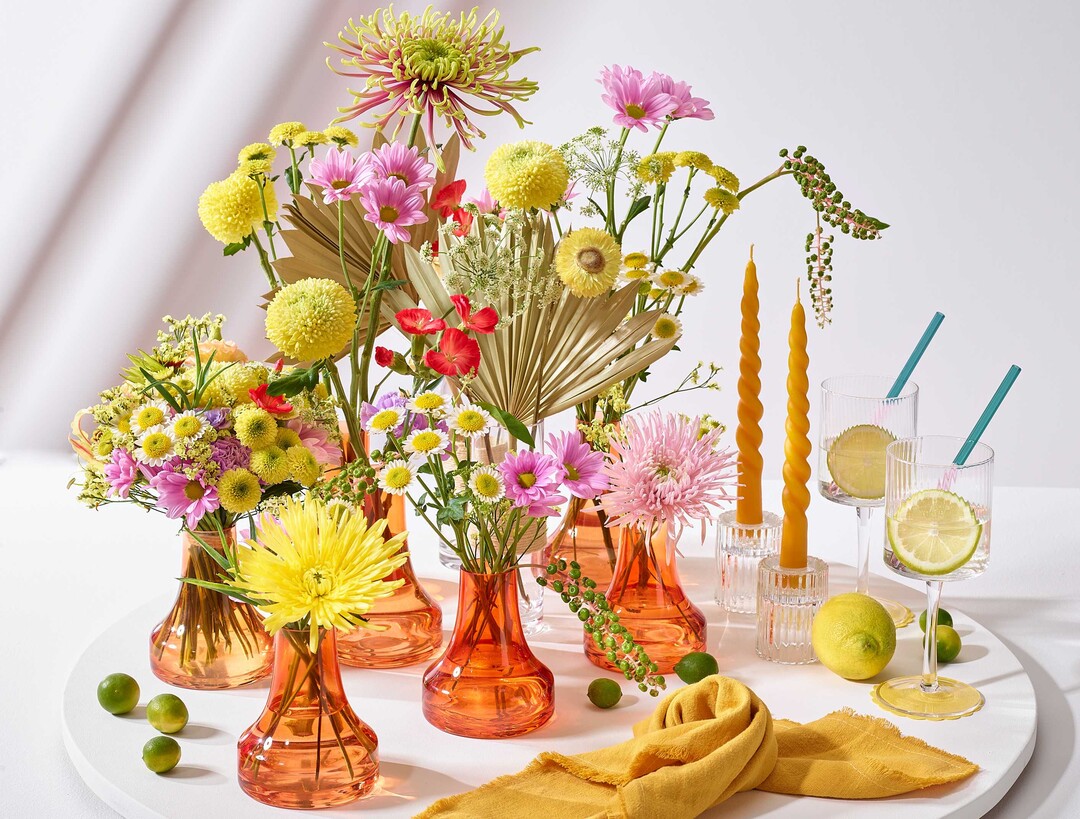 Chrysanthemen-Blüten und ein Sträußchen werden zur unkomplizierten sommerlichen Tisch-Dekoration arrangiert. Retro, fröhlich, dekorativ und günstig. Für junge Konsumenten, die Cocktail-Party oder ein Get-together ohne großes Spektakel.
